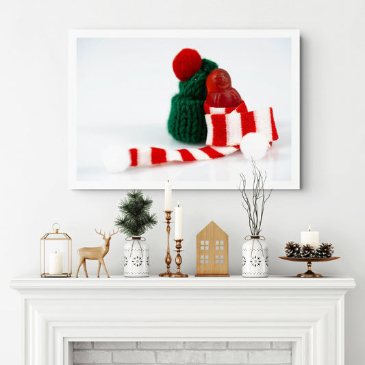 Santa Babies photographic artwork featuring a tiny red figure wrapped in a striped Christmas scarf displayed above a white fireplace.