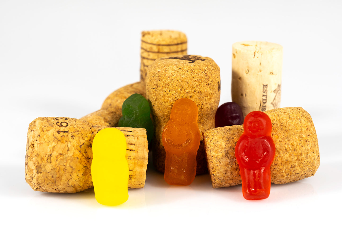 Yellow, orange, red, green and burgundy confectionery figures gathered among assorted wine corks in What A Corker - 266641v1.