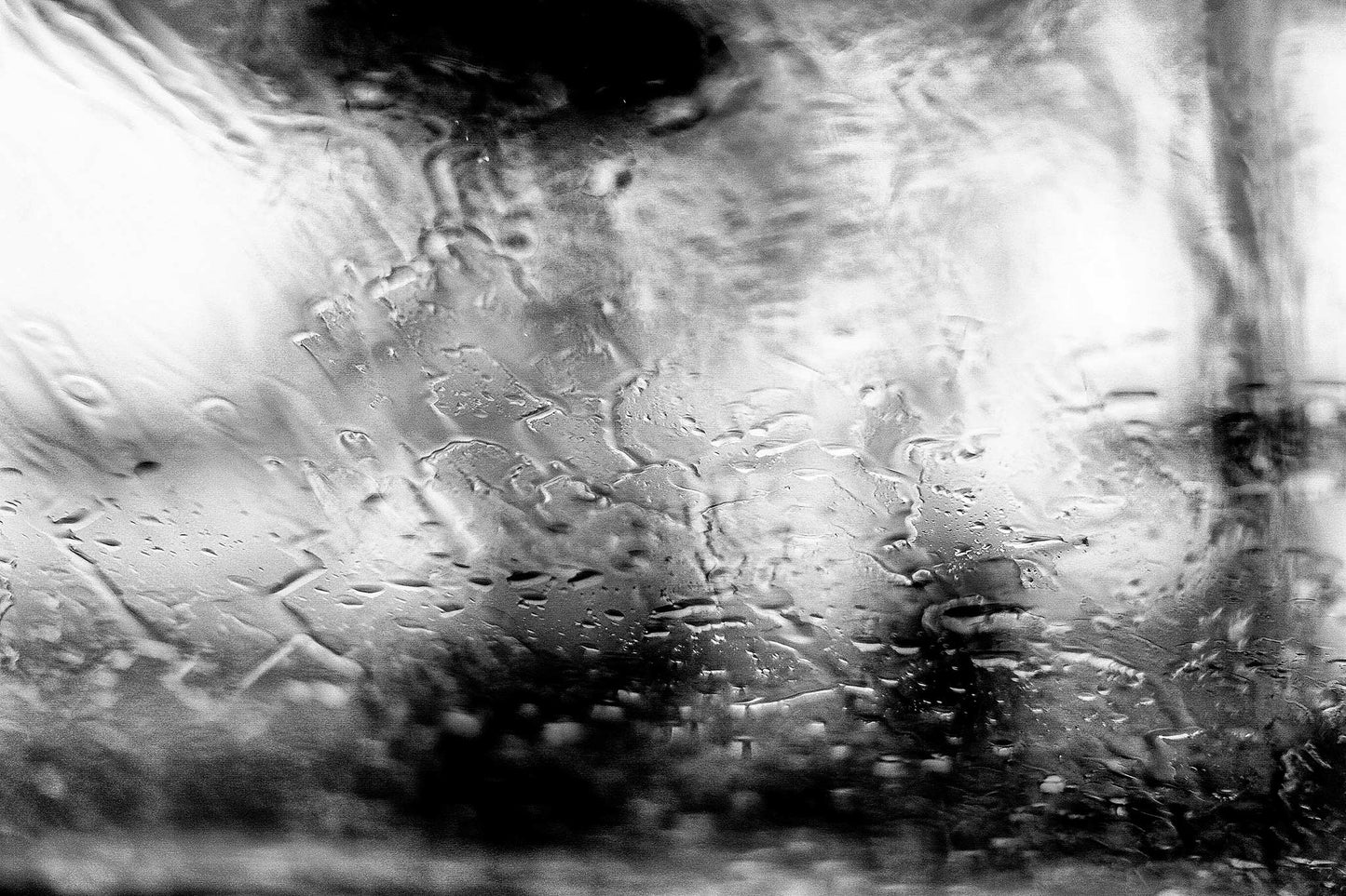 Coastal Noir 7185 - 90x60cm, Black and white abstract coastal photograph with people with umbrellas blurred behind rain-speckled glass, minimalist fine art print.