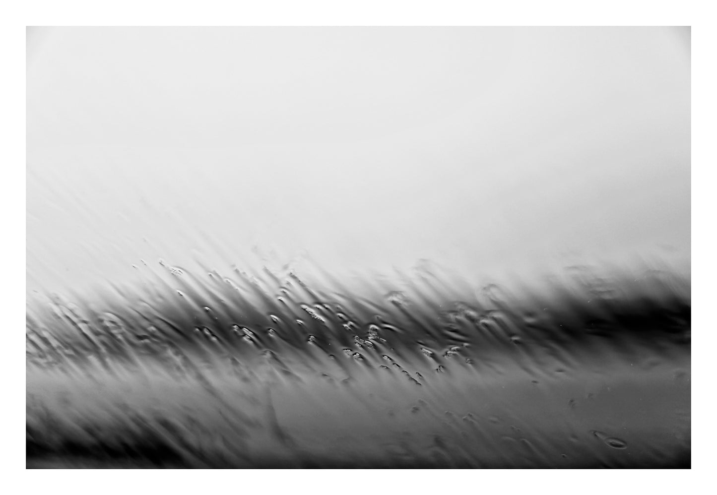 Coastal Noir 7669 - 104x74cm, monochrome photograph of rippling water and shoreline blurred by rain droplets on glass, minimalist abstract coastal print.
