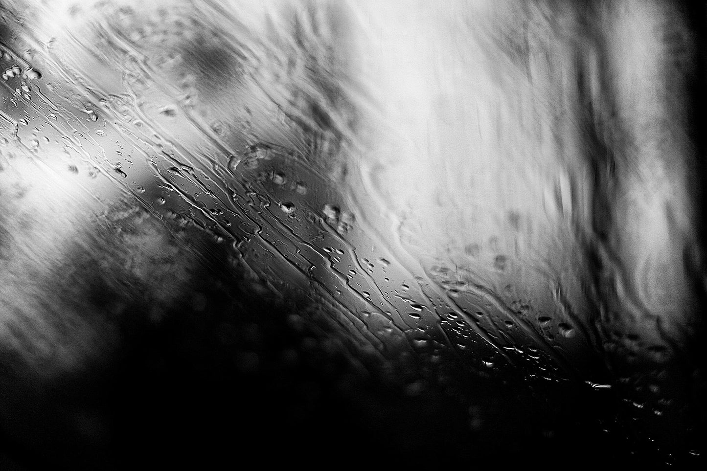 Coastal Noir 7933 - 90x60cm, abstract black and white coastal image with fine rain droplets on glass creating subtle horizontal lines and textures.