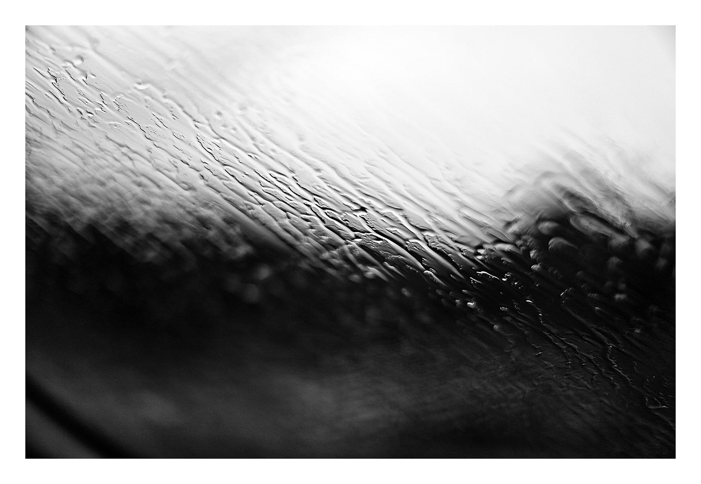 Coastal Noir 7952 - 104x74cm, monochrome photograph with rippling water and rain-speckled glass creating soft abstract coastal textures.