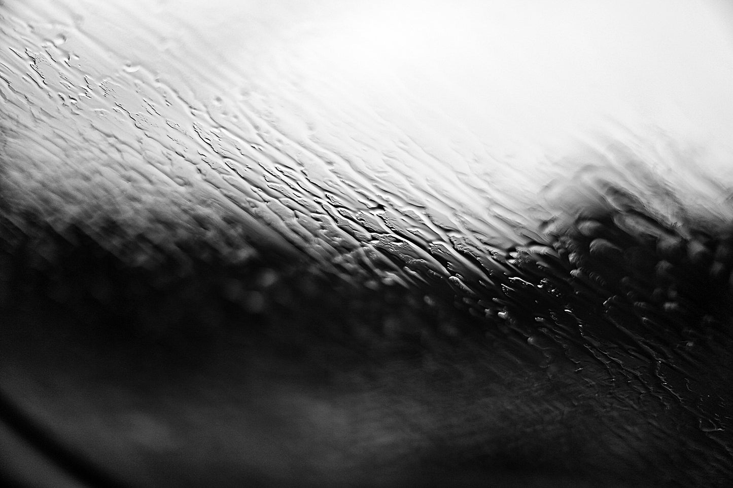 Coastal Noir 7952 - 90x60cm, monochrome photograph with rippling water and rain-speckled glass creating soft abstract coastal textures.