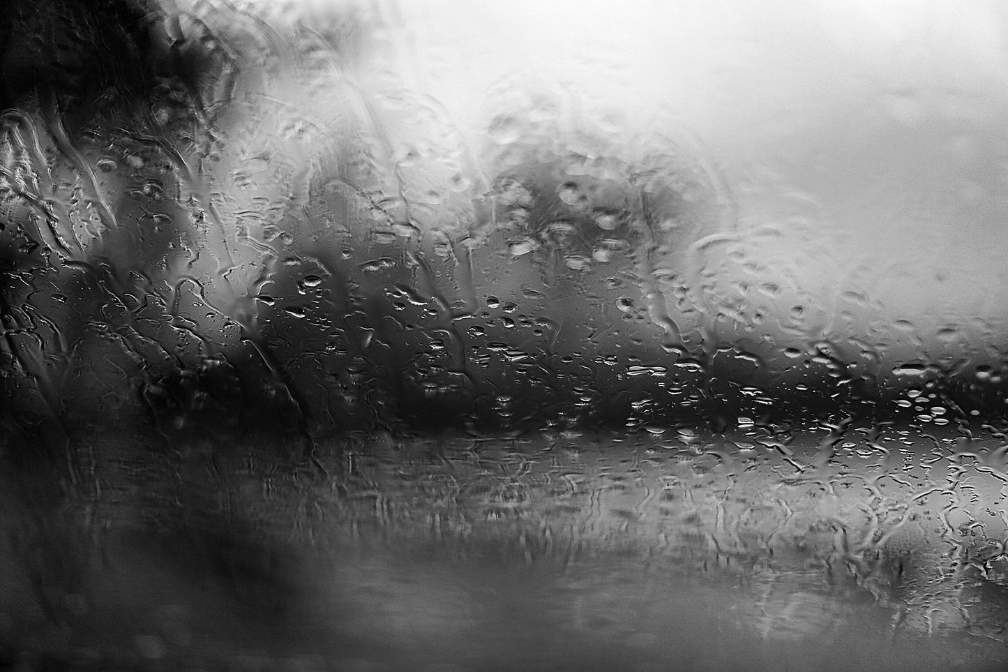 Coastal Noir 7974 - 90x60cm, black and white coastal photograph with rain-speckled glass creating soft abstract forms and horizontal flow.