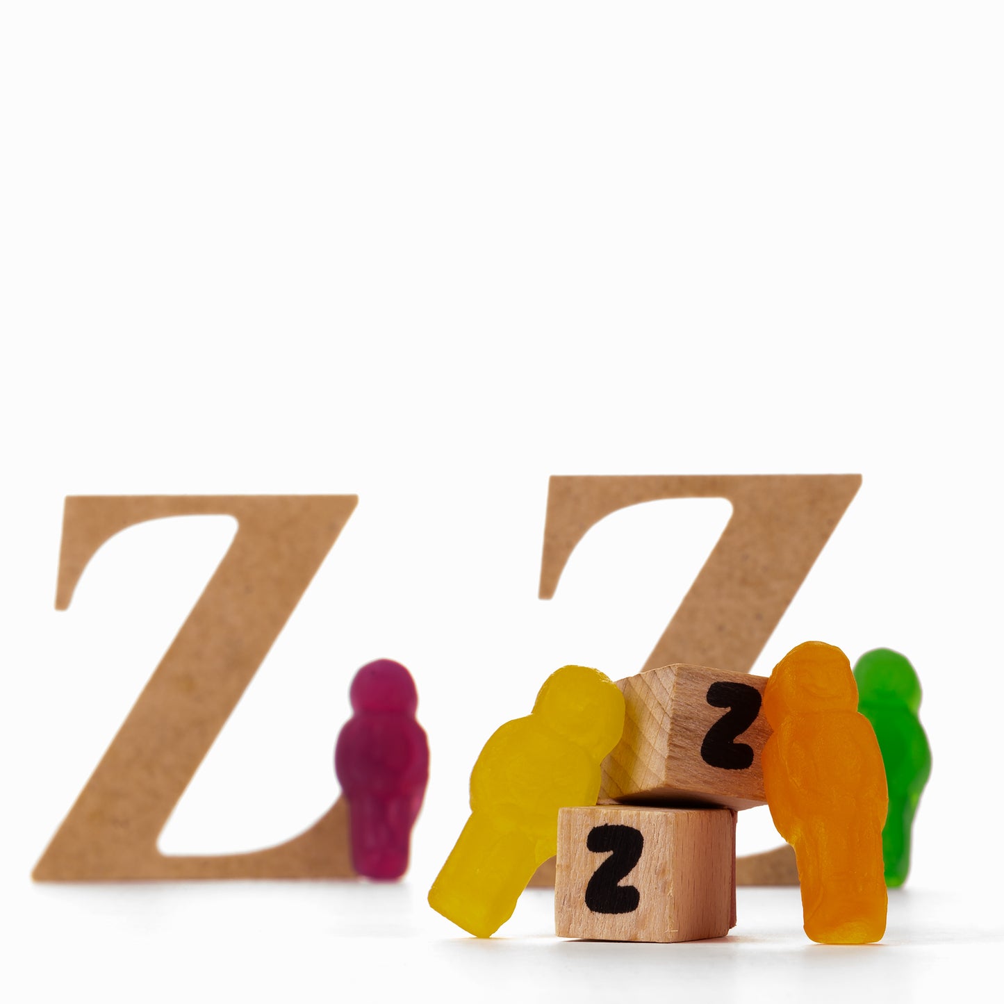 Catching Some ZZZ's 1493 - 60x60cm, colourful jelly figures resting against wooden cubes with painted Zs, playful fine art still life by Raymond Mather, ART1.