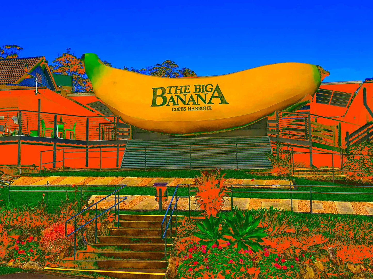 Vivid Country - Coffs Harbour Big Banana - 2173v56a - 90x67.5cm, a vibrant Pop Art interpretation of the iconic Big Banana roadside attraction, set against a bright blue sky with exaggerated orange and green foreground.