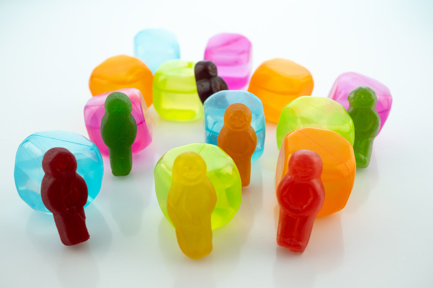 Cold As Ice 2698 - 90x60cm, colourful jelly baby figures paired with translucent faux ice cubes in a staged still life composition, exploring contrast, isolation, and pop-art humour, by Raymond Mather, ART1.