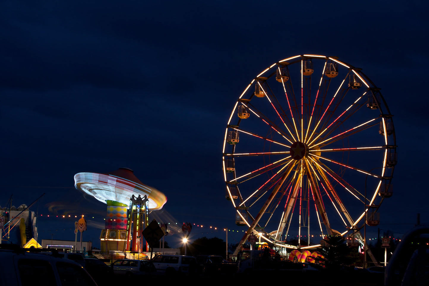 Fairground Carnival Lights 6900003v3 - 90x60cm, Ferris wheel glowing against twilight sky with carnival rides below, fine art limited edition print by Raymond Mather, ART1.