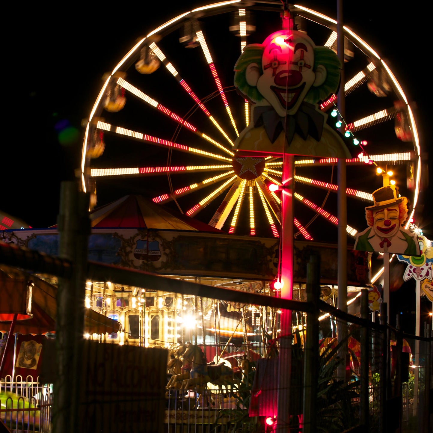 Fairground Carnival Lights 6900083 - Close Detail View, night carnival view with Ferris wheel, glowing rides, and striking clown figure, fine art limited edition print by Raymond Mather, ART1.