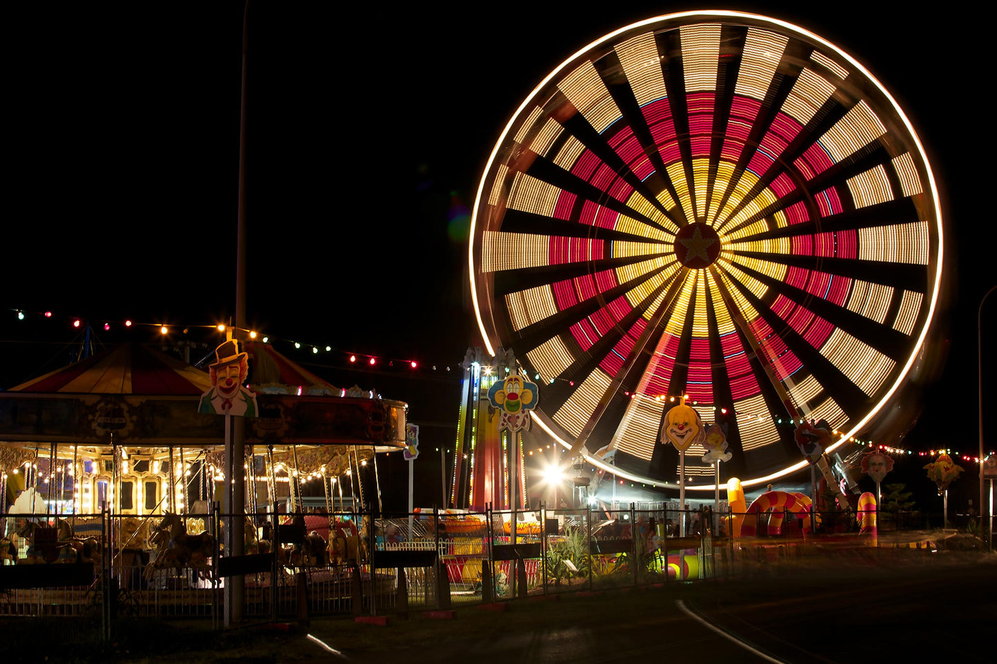Fairground Carnival Lights 6900116 - 90x60cm, Ferris wheel with bold red and yellow pattern and carnival lights at night, fine art limited edition print by Raymond Mather, ART1.
