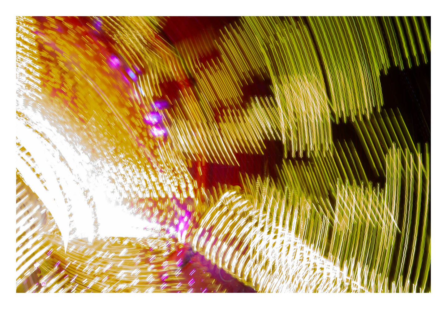 Fairground Carnival Lights 6900131 - 104x74cm, an abstract long exposure of carnival lights in motion, forming sweeping ribbons of gold, red, white, and purple across the frame. Captured by Raymond Mather, this fine art photograph transforms fairground energy into a dynamic light composition.
