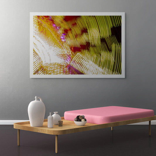 Fairground Carnival Lights 6900131 - Room View, an abstract long exposure of carnival lights in motion, forming sweeping ribbons of gold, red, white, and purple across the frame. Captured by Raymond Mather, this fine art photograph transforms fairground energy into a dynamic light composition.