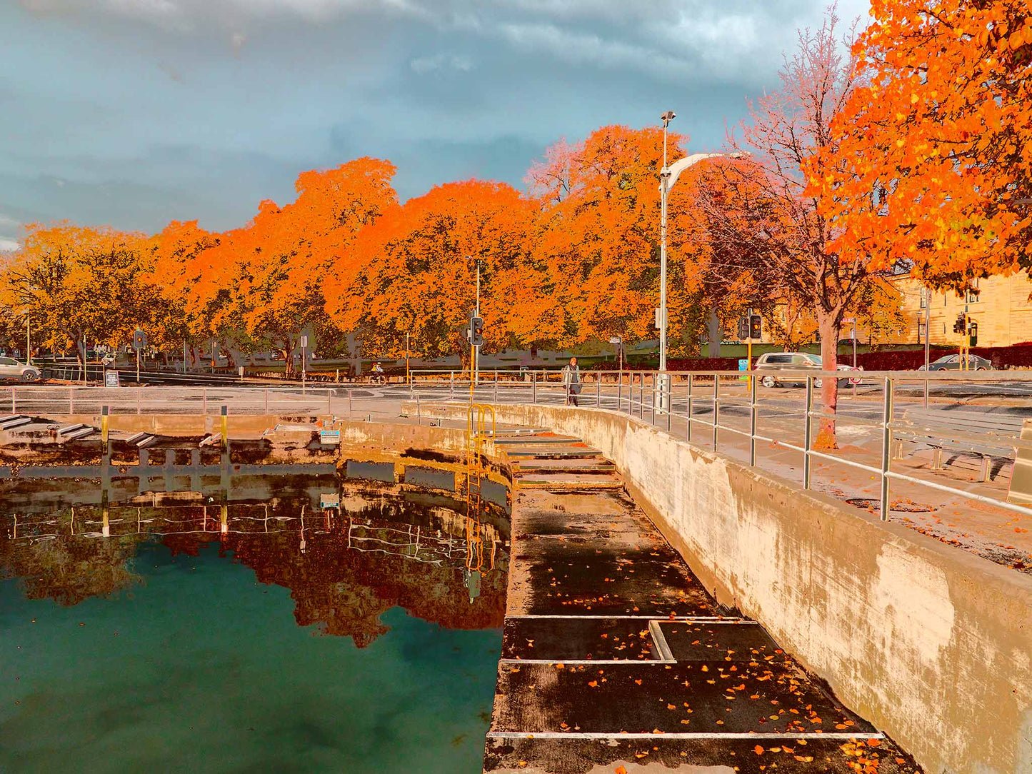 Vivid Country - Hobart Waterfront Esplanade - 0119v11a - 90x67.5cm, a richly coloured Pop Art-inspired view of Hobart’s waterfront showing a calm harbour edge, autumn leaves on the pavement, and a vibrant row of golden-orange trees under a grey-blue sky.