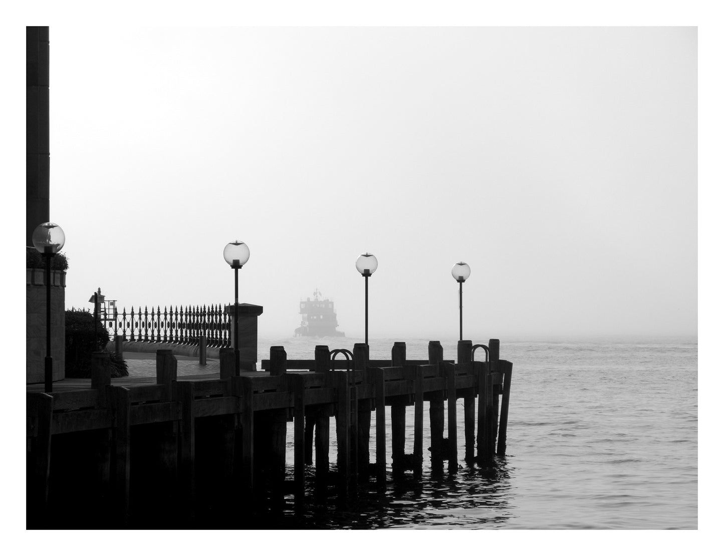 Monochrome Mix - Ferry in the Mist - 1720675 - 104x81.5cm, A ferry appears through heavy mist beyond a quiet dock with vintage lamp posts, rendered in soft black and white. Moody, atmospheric waterscape Sydney Harbour. Limited edition fine art print.