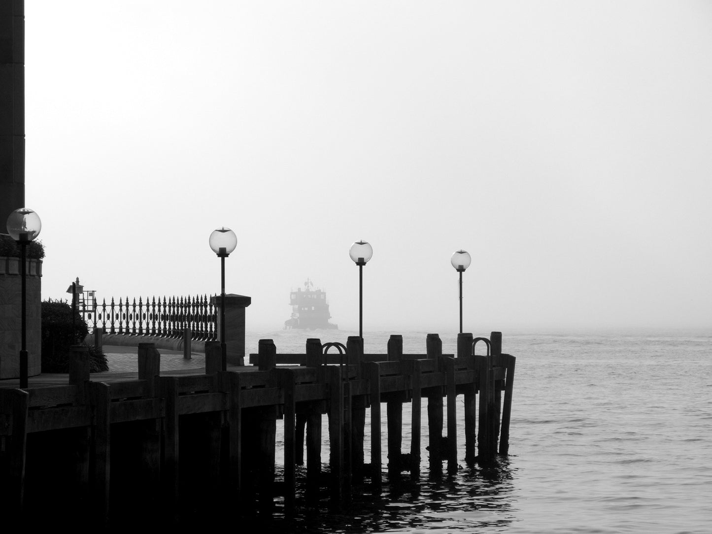 Monochrome Mix - Ferry in the Mist - 1720675 - 90x67.5cm, A ferry appears through heavy mist beyond a quiet dock with vintage lamp posts, rendered in soft black and white. Moody, atmospheric waterscape Sydney Harbour. Limited edition fine art print.