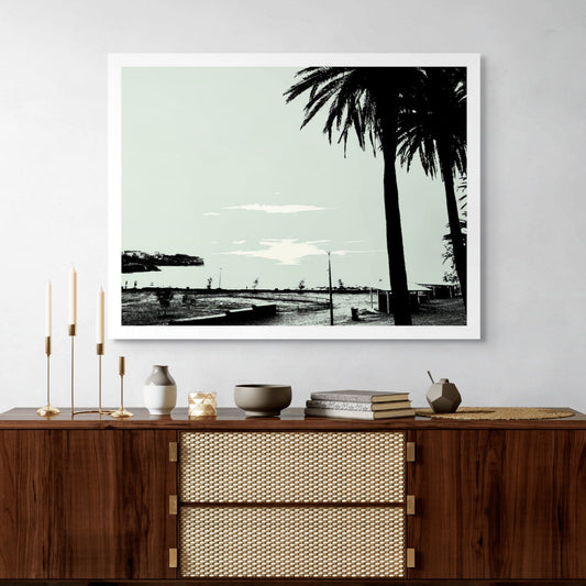POPscape Sydney - Bronte Beach - 140128v31 - Room View, Minimalist pop-art image of Bronte Beach with silhouetted palm trees in the foreground and a pale sky over a quiet coastal headland.