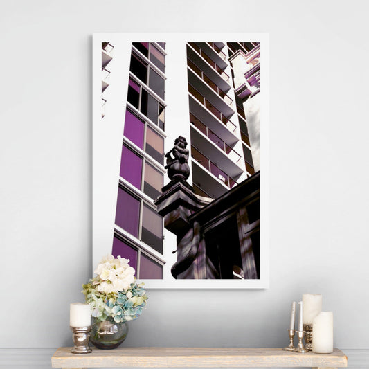 POPscape Sydney - Darlinghurst - Building Statue - 1906064v16 - Room View, Stylised image of a cherub statue atop a heritage building, surrounded by modern high-rise architecture in Darlinghurst. Muted purples and dark tones create dramatic Pop Art contrast.