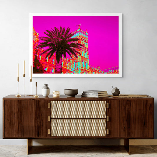 POPscape Sydney - Manly - Castle Palm - 3615v17 - Room View, Stylised image of a large palm tree in front of a historic stone building in Manly, Sydney. The scene is bathed in vivid neon colours with a magenta sky, evoking a Pop Art fantasy.