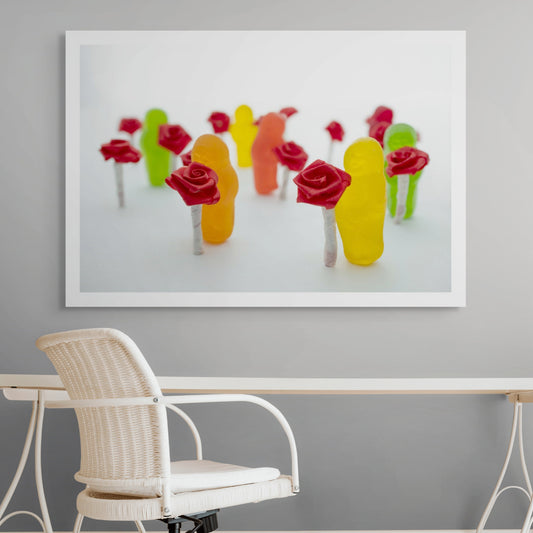 Stop and Smell the Roses 2836v1 - Room View, playful fine art photograph by Raymond Mather featuring colourful jelly baby figures holding miniature red ribbon roses, arranged in a dreamlike procession on a soft white backdrop, evoking mindfulness and delight.