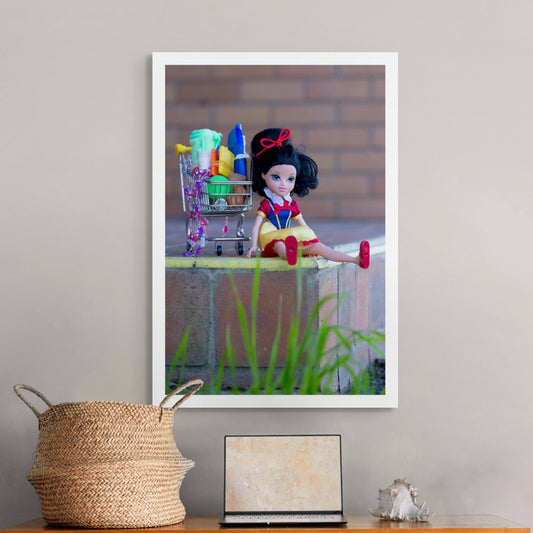 Trolley Dolly - Series No.1: 197317 - Room View, a Snow White doll sits on a brick ledge next to a miniature shopping trolley filled with soaps, cloths, and small household items. Her red shoes hang over the edge. The image reflects themes of homelessness, resilience, and femininity.
