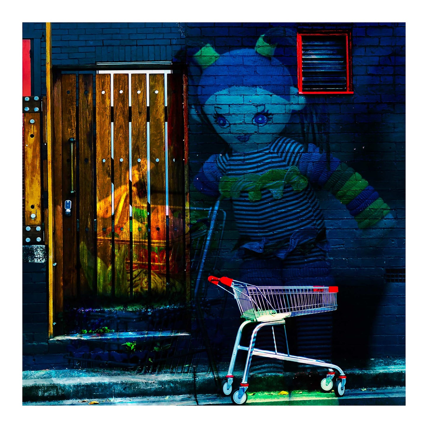 Trolley Dolly - Series No.2: 9255v3 - 74x74cm, a surreal urban street scene featuring a large doll overlaid against a dark brick wall, her striped outfit and outstretched arms glowing in soft hues. In the foreground, a shopping trolley with red handles is parked on the footpath. A textured wooden door and a red trimmed vent hint at hidden stories. The layered composition conveys a dreamlike tension between innocence and abandonment, reflecting on homelessness and social neglect.