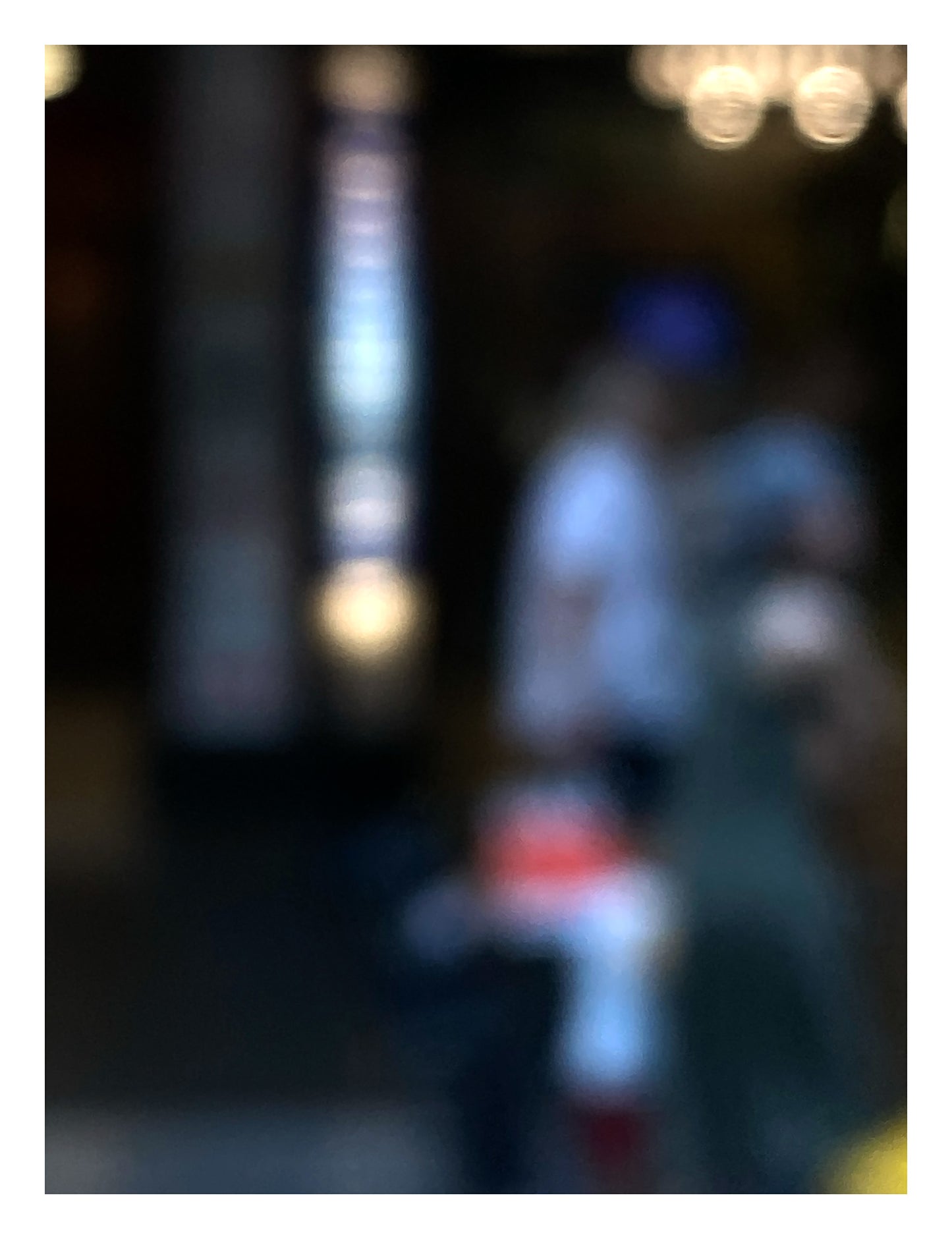 Urban Commute - Series No.1: 0974v1 - 81.5x104cm, a soft-focus photograph of two blurred adult figures with a small child in red and white, framed by glowing city lights and vertical signage. A quiet moment of connection and motion captured in painterly abstraction. Limited edition fine art print by Raymond Mather.
