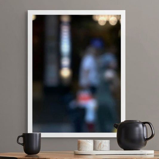 Urban Commute - Series No.1: 0974v1 - Room View, a soft-focus photograph of two blurred adult figures with a small child in red and white, framed by glowing city lights and vertical signage. A quiet moment of connection and motion captured in painterly abstraction. Limited edition fine art print by Raymond Mather.