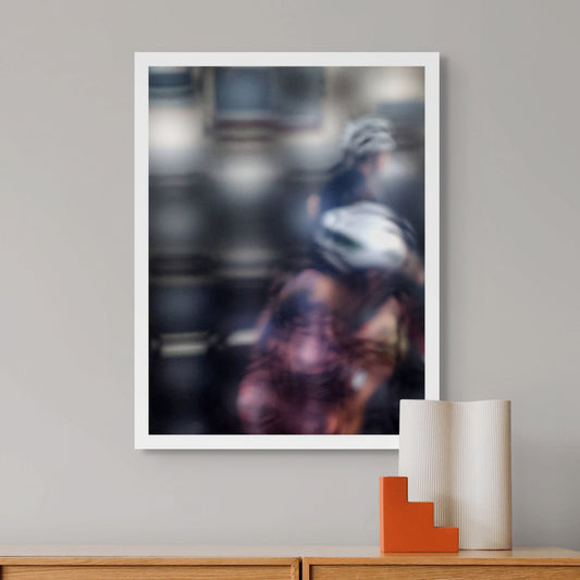 Urban Commute - Series No.2: 8622(1) - Room View, fine art photograph by Raymond Mather featuring two blurred cyclists in motion, seen through a diffused surface. The image blends pink, navy, and silver tones into an abstract composition of rhythm, reflection, and fleeting urban energy.