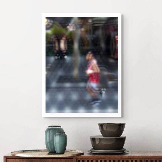 Urban Commute - Series No.2: 9199v1 - Room View, fine art photograph by Raymond Mather featuring a blurred runner in red, captured mid-stride through a soft patterned lens. The urban backdrop is abstracted into colour and shadow, evoking a dreamlike sense of motion and energy.