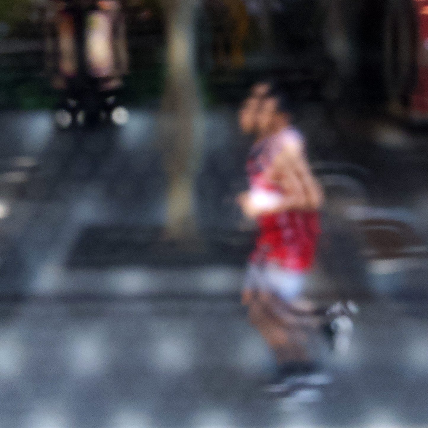 Urban Commute - Series No.2: 9199v1 - Close Detail View, fine art photograph by Raymond Mather featuring a blurred runner in red, captured mid-stride through a soft patterned lens. The urban backdrop is abstracted into colour and shadow, evoking a dreamlike sense of motion and energy.