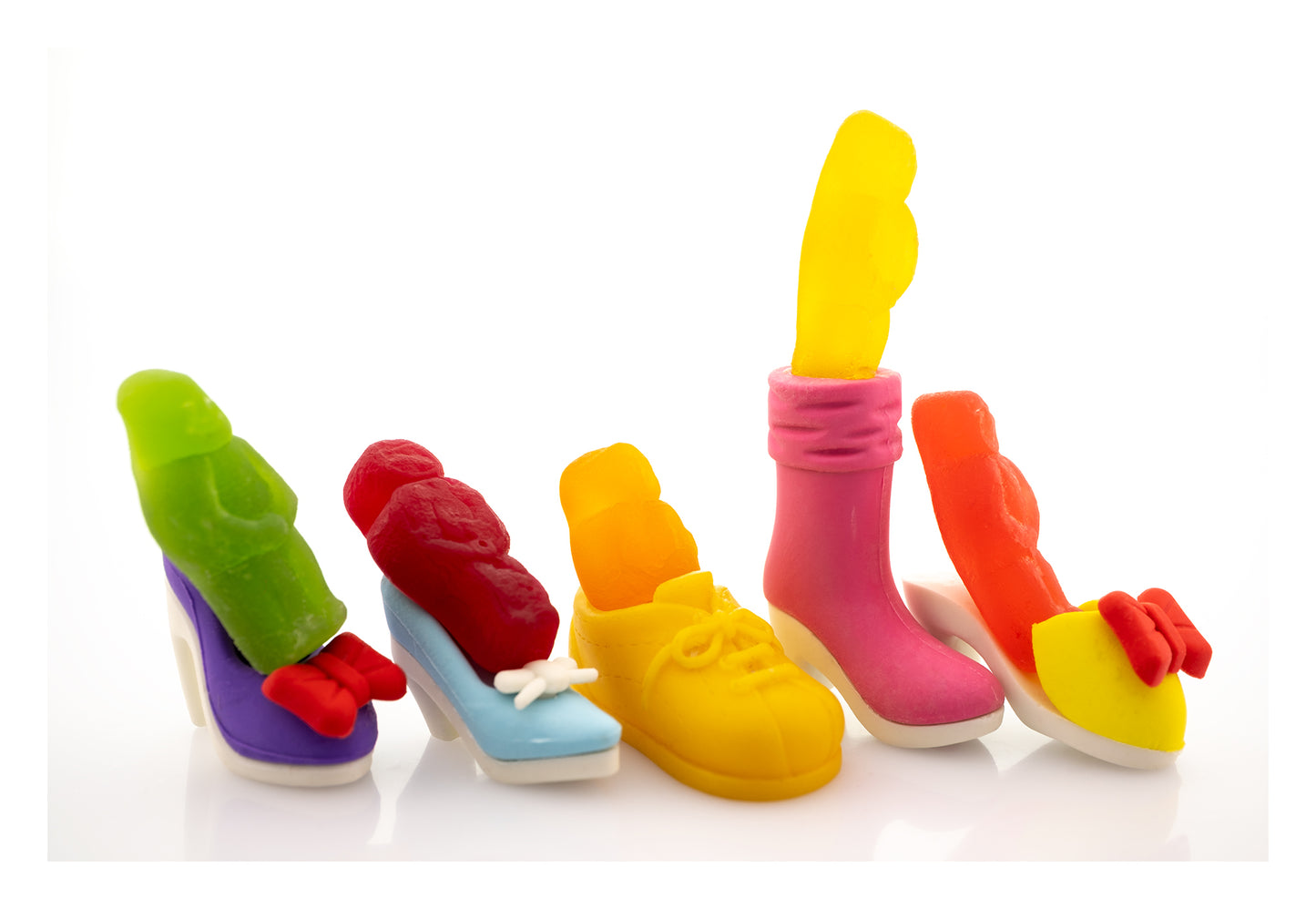 Walk a Mile in My Shoes 2805v1 - 104x74cm, fine art photograph by Raymond Mather featuring brightly coloured jelly baby figures placed playfully inside an eclectic mix of miniature shoes. A pop art composition that brings a humorous twist to empathy and individuality.