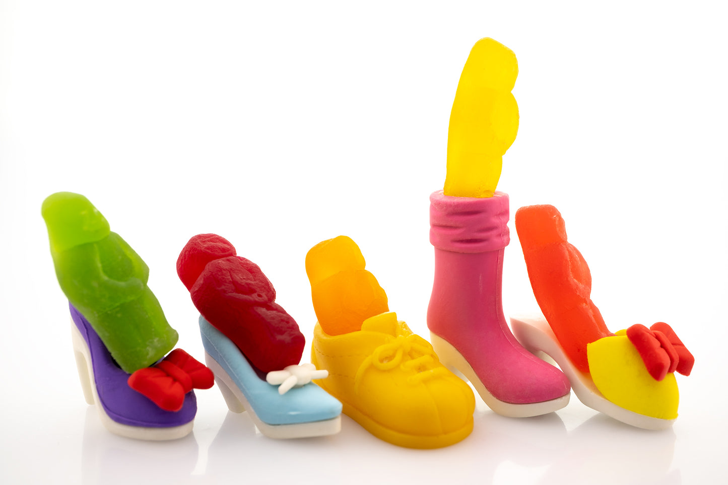 Walk a Mile in My Shoes 2805v1 - 90x60cm, fine art photograph by Raymond Mather featuring brightly coloured jelly baby figures placed playfully inside an eclectic mix of miniature shoes. A pop art composition that brings a humorous twist to empathy and individuality.