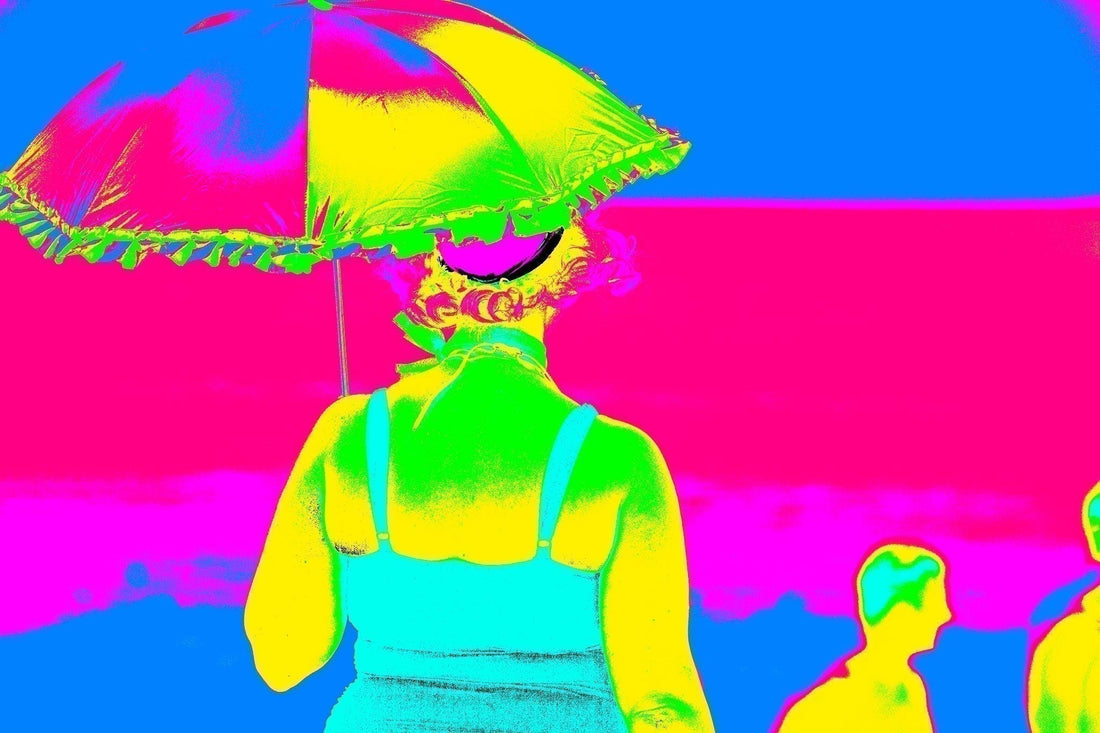 Vivid Country Mix a woman with umbrella on the beach, abstract neon colours against a vivid pink and blue horizon, reimagined in Raymond Mather’s Pop Art style
