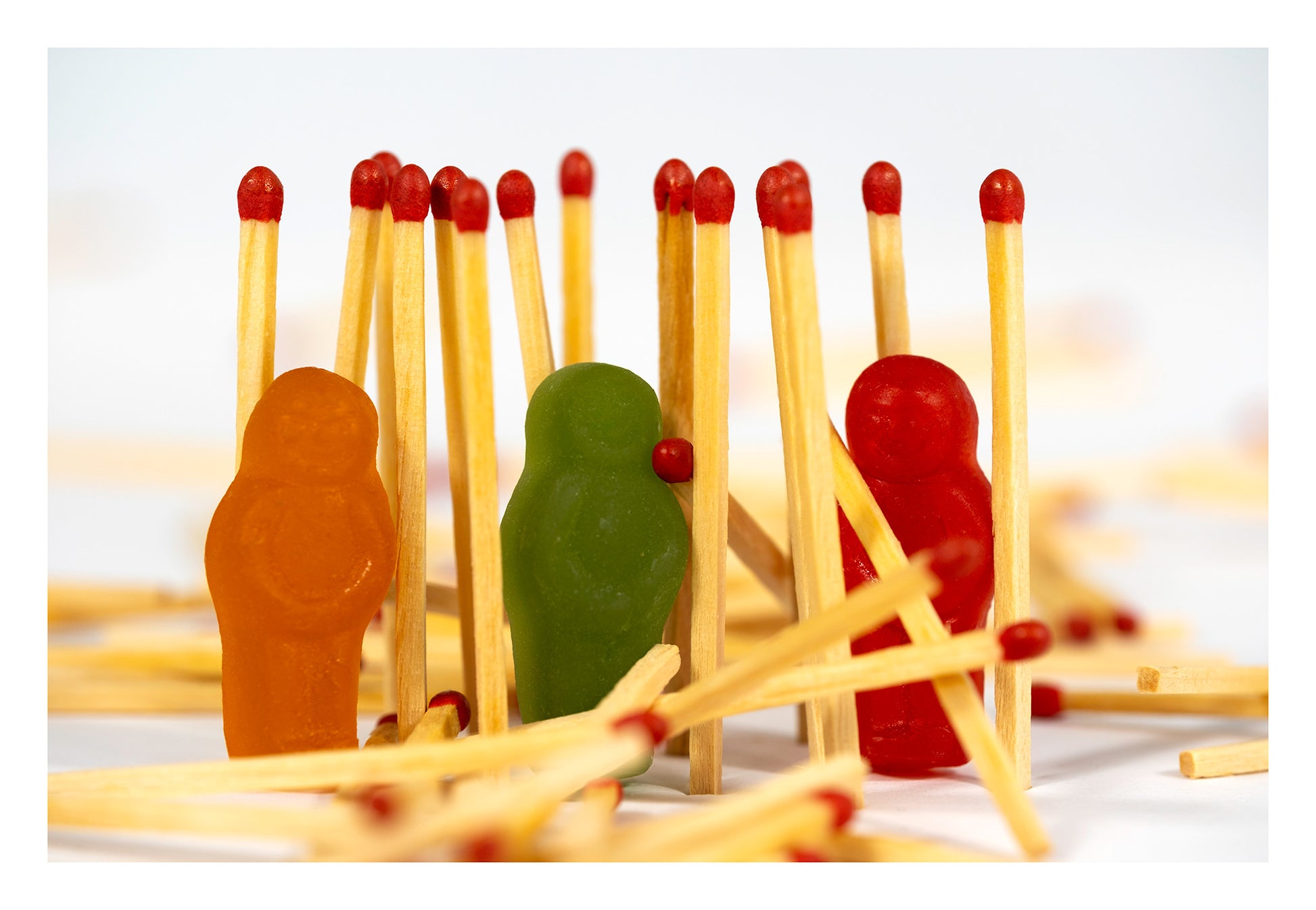 Baby Light My Fire photographic artwork with orange, green and red jelly baby figurines and red-tipped matches, presented with a white print border.
