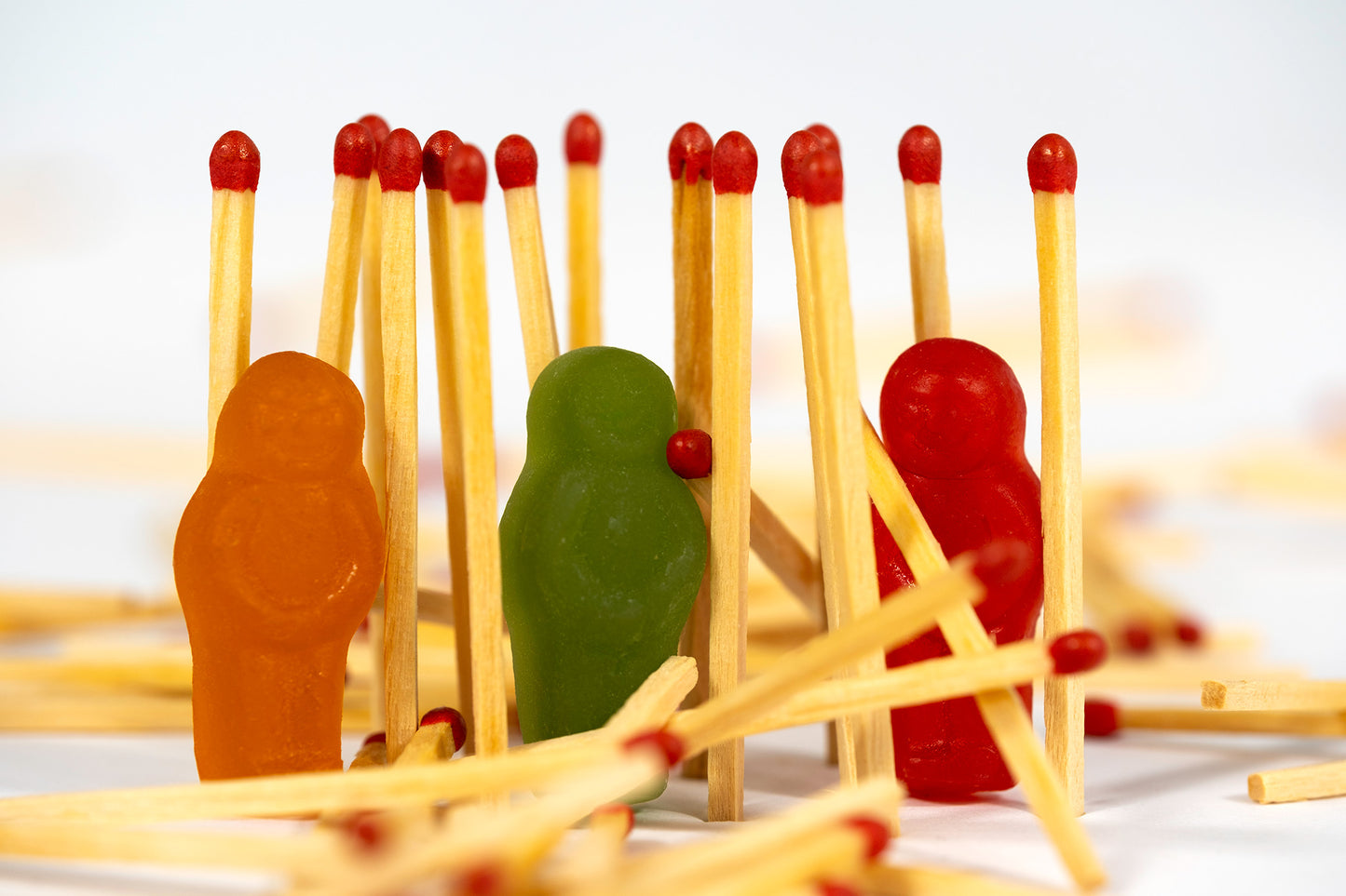 Baby Light My Fire still life photograph of colourful jelly baby figurines standing among red-tipped wooden matches.