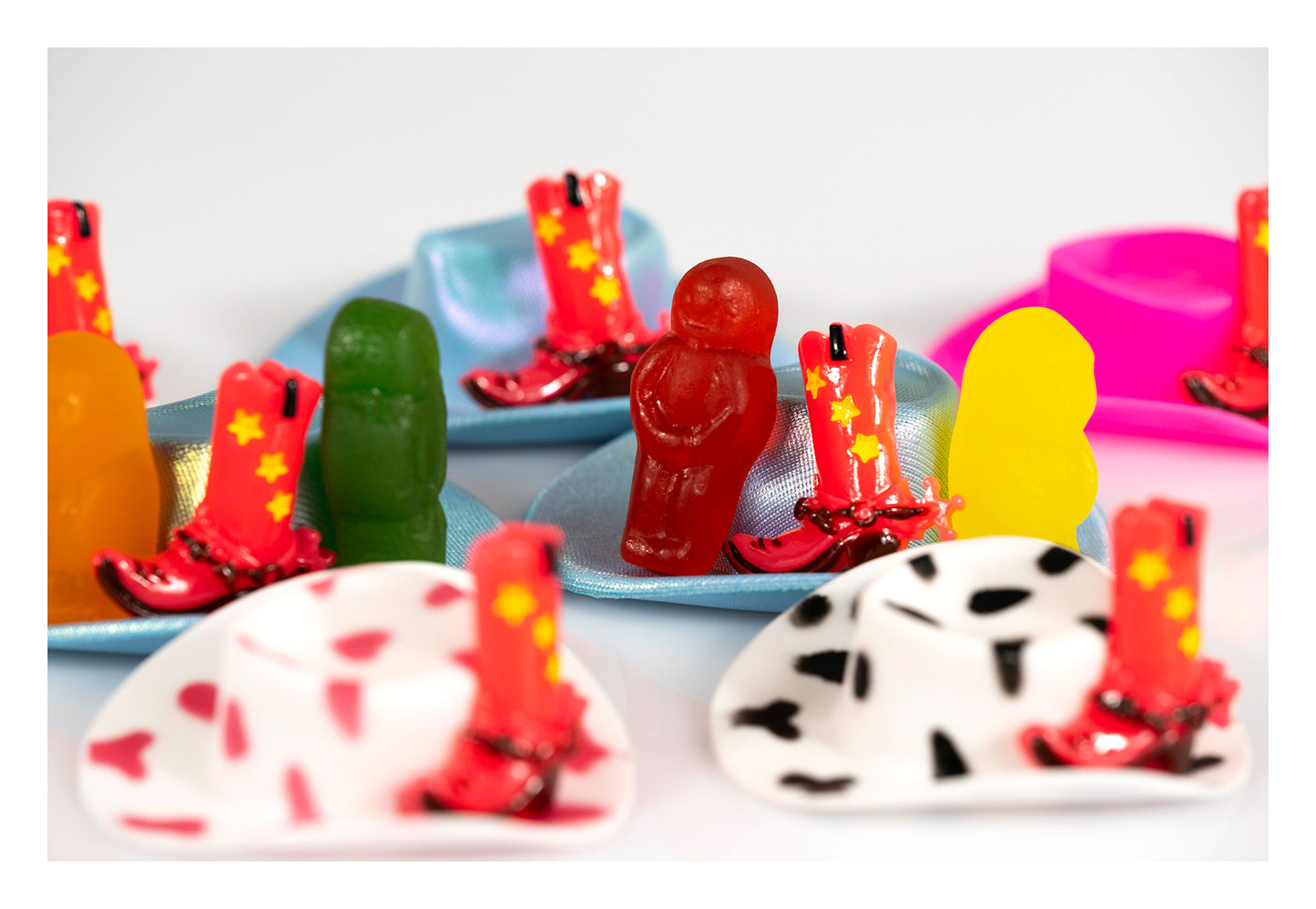 Boot Scootin Baby by Australian photographer Raymond Mather, colourful jelly babies with miniature blue cowboy hats and red cowboy boots, ART1.