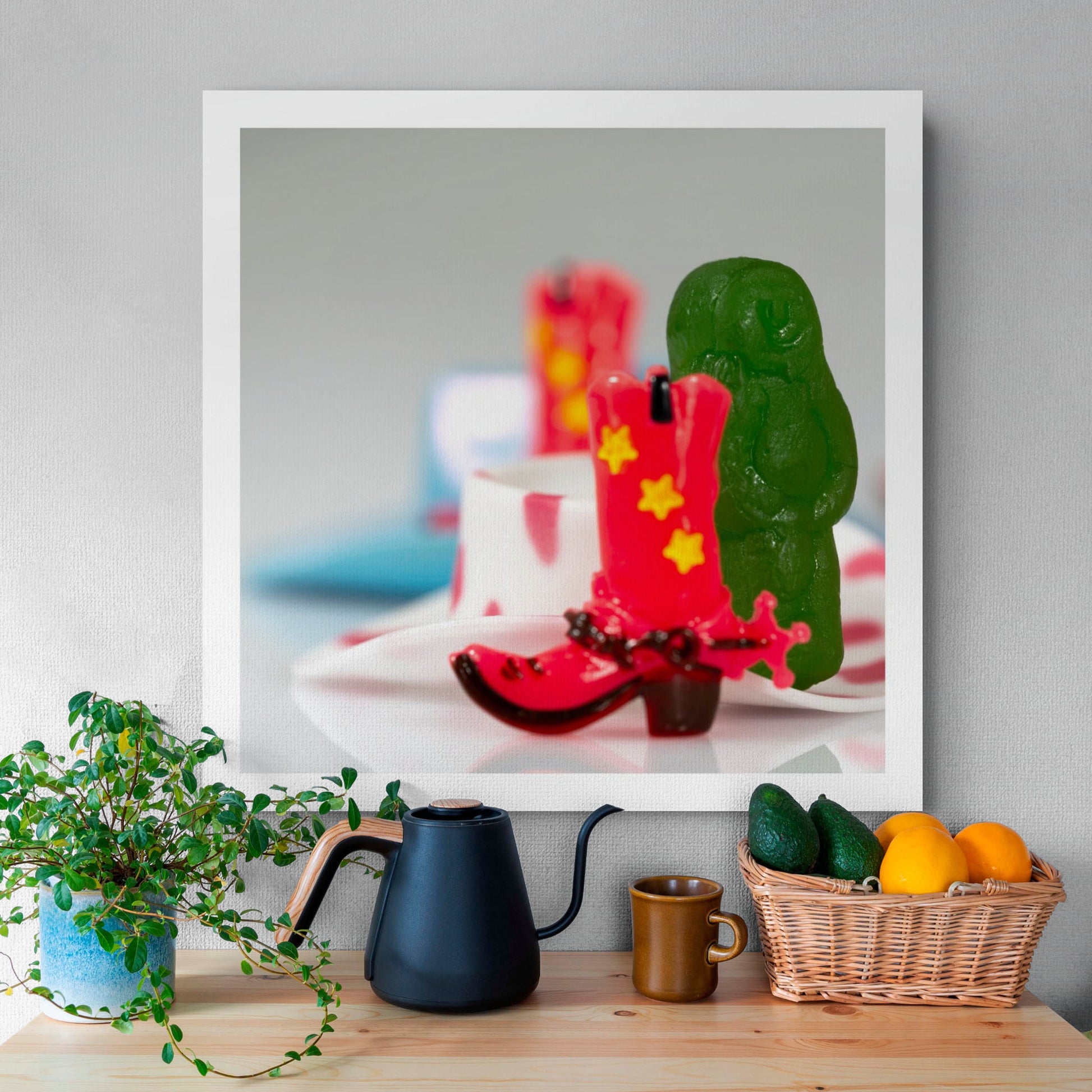 Boot Scootin’ Baby 266835v1 by Raymond Mather displayed as a square photographic artwork above a timber table with plants, black kettle and fruit basket.