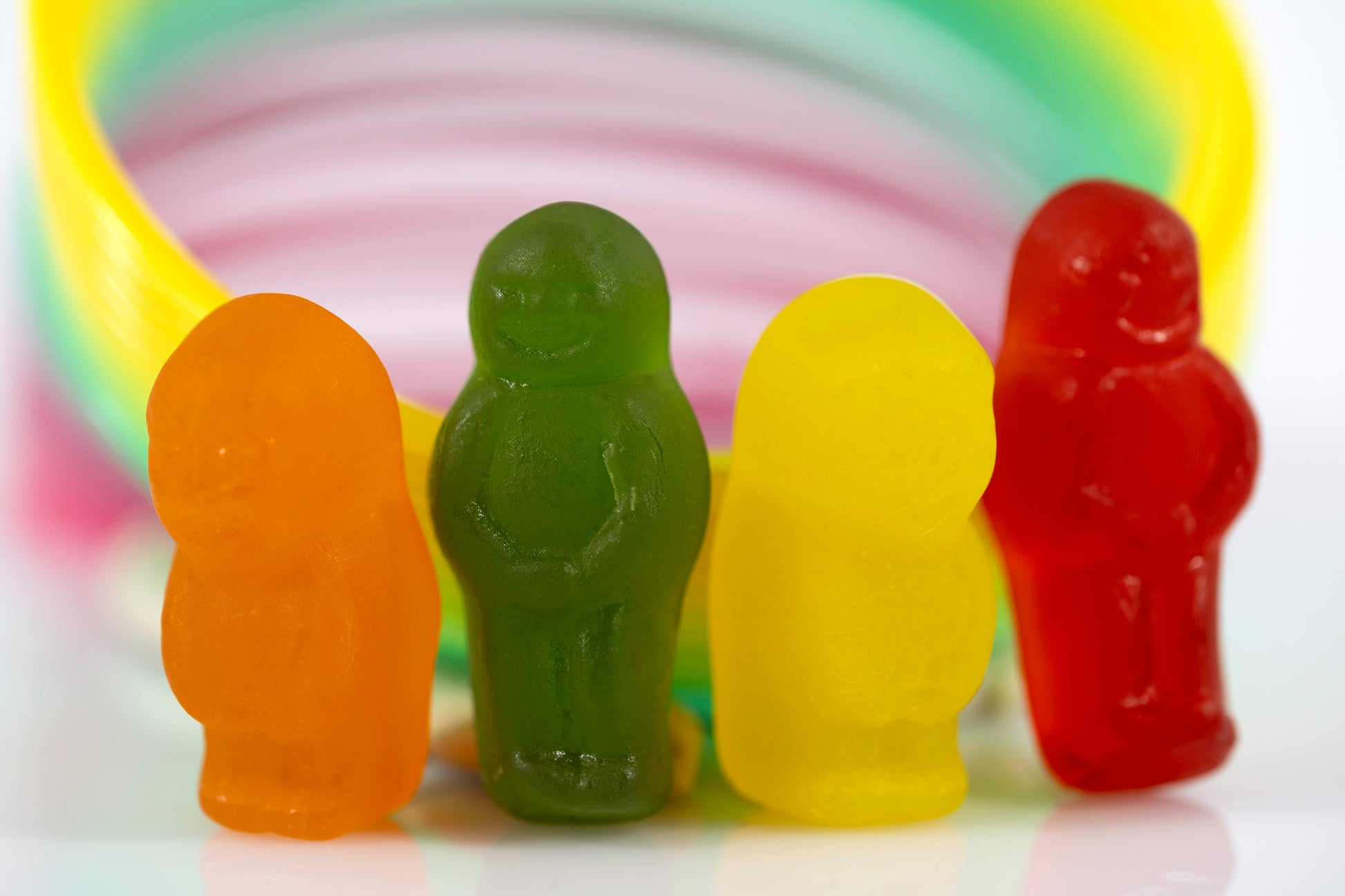 Four colourful miniature figures grouped together against a bright circular multicoloured background.