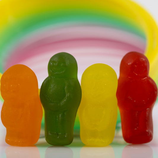 Close-up of four colourful miniature figures grouped together beneath a sweeping multicoloured circular form.