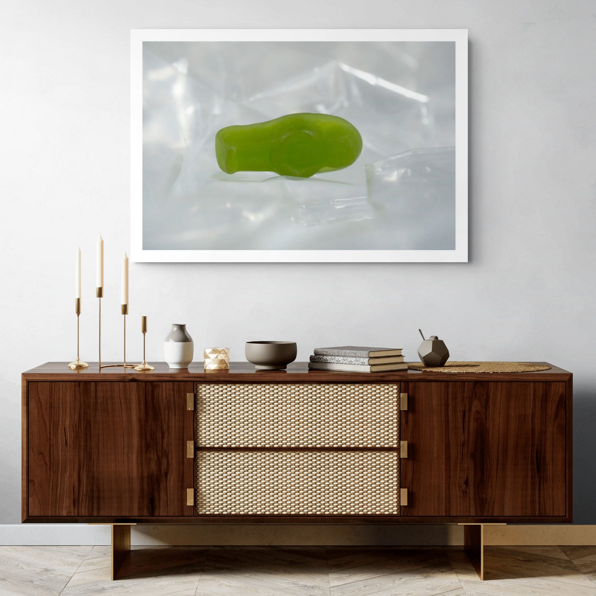 Sleep Like A Baby photographic artwork showing a small translucent green baby-shaped figure lying within pale transparent material in a contemporary interior.
