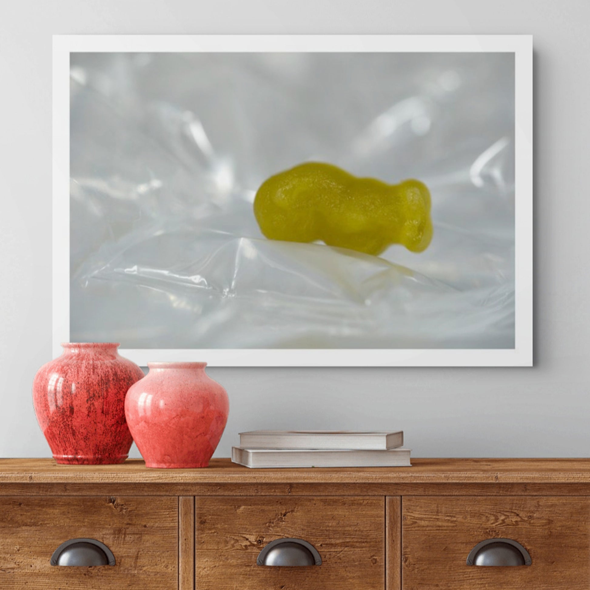 Sleep Like A Baby photographic artwork featuring a yellow baby-shaped figure resting among pale reflective folds, displayed above a timber cabinet.