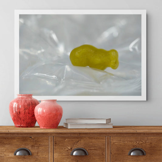 Sleep Like A Baby photographic artwork featuring a yellow baby-shaped figure resting among pale reflective folds, displayed above a timber cabinet.