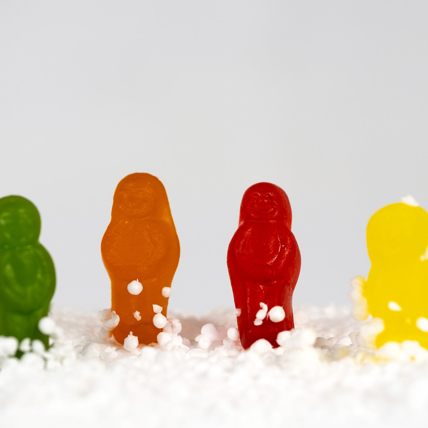 Snow Babes - 267029v1 by Raymond Mather. Close-up crop of colourful confectionery figures surrounded by white snow-like material.