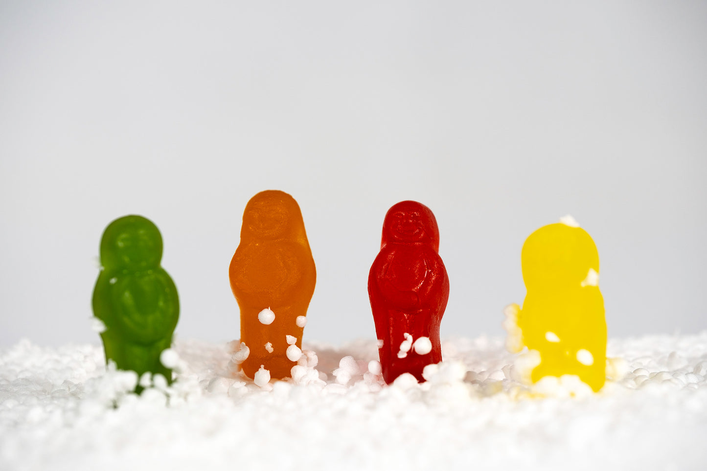 Snow Babes - 267029v1 by Raymond Mather. Four green, orange, red and yellow confectionery figures standing within a white snow-like landscape.