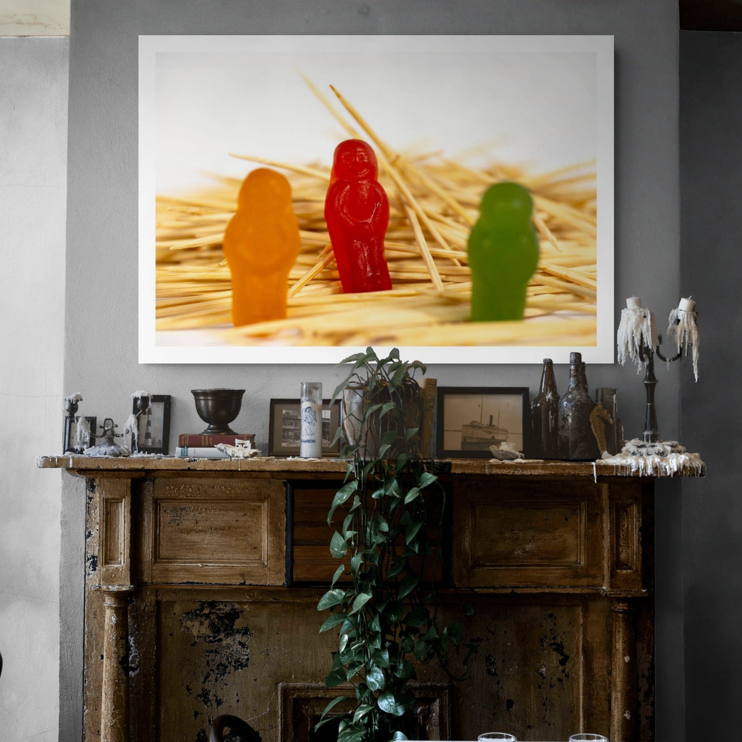 What A Pick - 267283v1 photographic artwork featuring three colourful confectionery figures among a dense field of wooden toothpicks, displayed above a rustic fireplace.