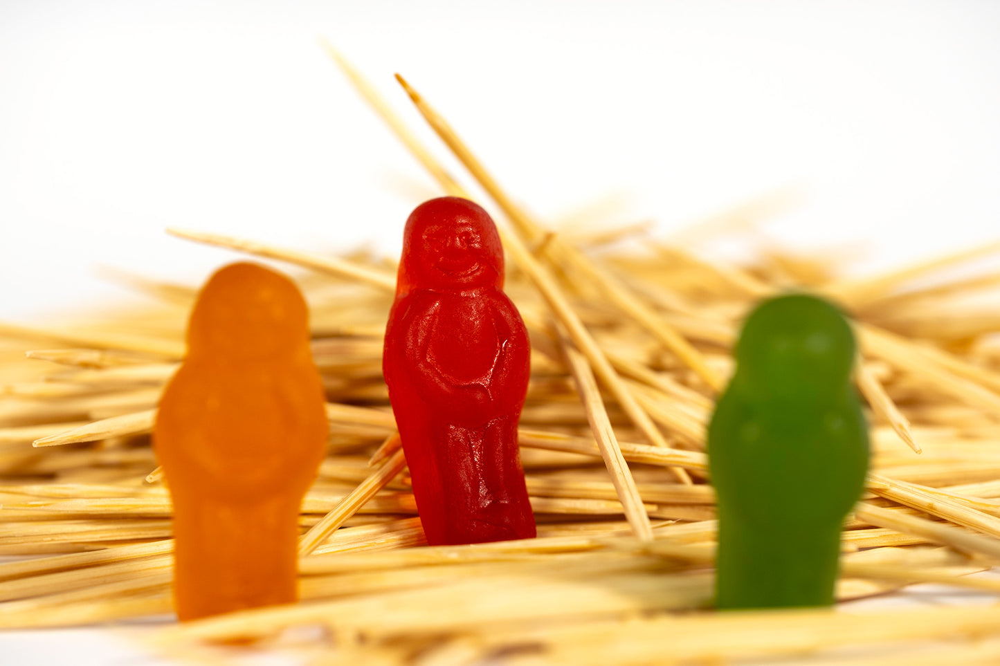 Three colourful confectionery figures surrounded by scattered wooden toothpicks, with the central red figure sharply focused in What A Pick - 267283v1.