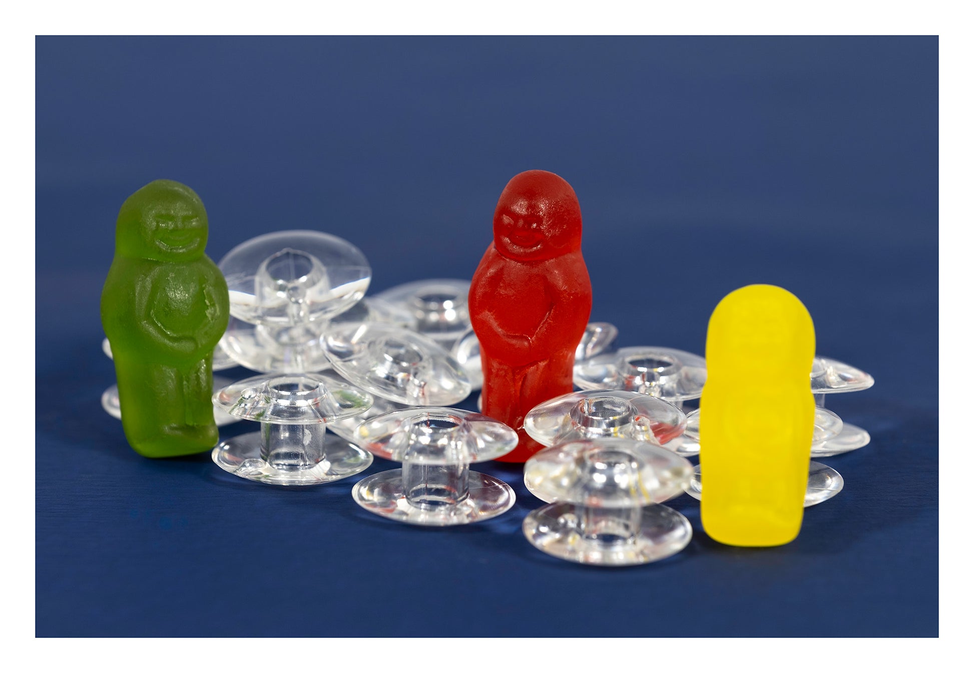 Bobbin Around photographic artwork with colourful jelly baby figurines and transparent sewing machine bobbins, presented with a white print border.
