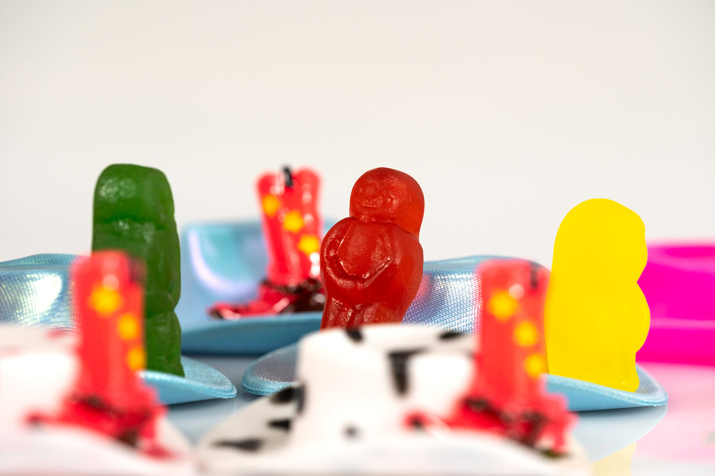 Boot Scootin Baby by Australian photographer Raymond Mather, colourful jelly baby figurines among miniature cowboy hats and boots, ART1.