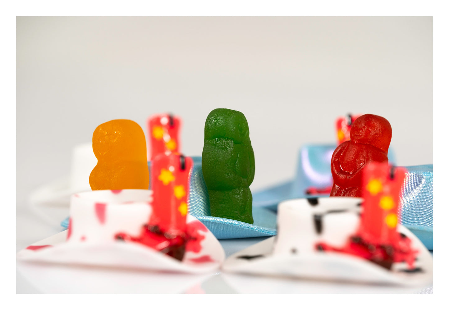 Boot Scootin Baby by Australian photographer Raymond Mather, colourful jelly baby figurines with miniature cowboy hats and red cowboy boots, ART1.
