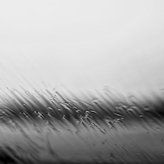 Coastal Noir 7669 - Close Detail View, monochrome photograph of rippling water and shoreline blurred by rain droplets on glass, minimalist abstract coastal print.